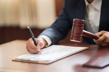 The lawyer is carrying a pen to write a case record in the courtroom