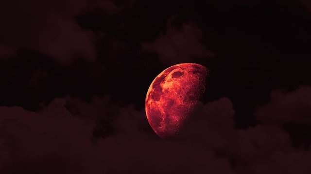 half red blood moon rise on the night sky and red cloud moving pass