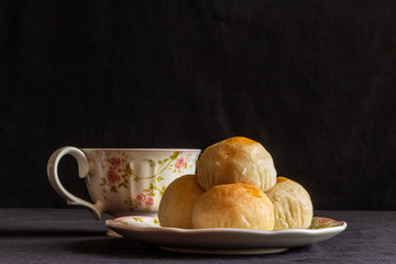 Traditional chinese cake on a plate with a cup of tea.