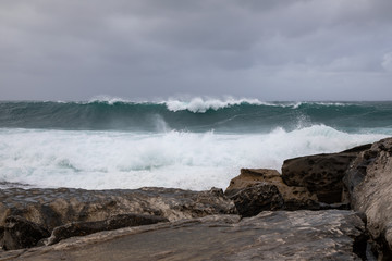 A huge wave is approaching to the ocean shore. Storm.