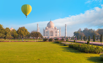 Obraz premium Hot air balloon flying over spectacular Taj Mahal at sunset - Agra, India