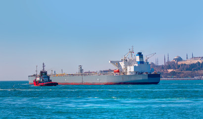 Tugboat assisting cargo ship sea at bosphorus - Famous historical peninsula of Istanbul - Hagia sophia, Sultanahmet Mosque, Topkapi Palace - Istanbul, Turkey