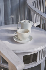 Cup of tea with ceramic tea pot on the white table