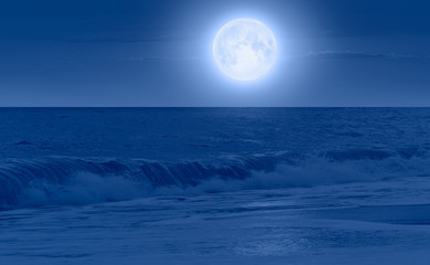 Full moon rising over empty ocean at night with power wave "Elements of this image furnished by NASA"