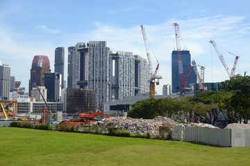 the excavator works in a fenced area where the building was destroyed
