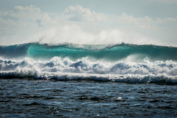 A huge wave for surfing . The photo was taken from the water in the Indian Ocean island of Mauritius
