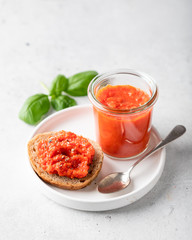Balkan traditional dish ajvar in a glass on a light background. 