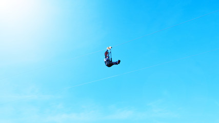 Motion blur of Extreme sportsman jumps on a rope with bright sunlight clear blue sky background.