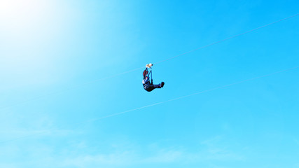 Fototapeta premium Motion blur of Extreme sportsman jumps on a rope with bright sunlight clear blue sky background.