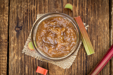 Rhubarb Jam on an old wooden table (close up shot; selective focus)