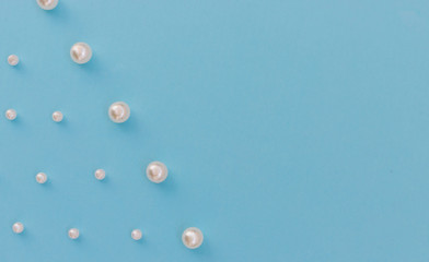 White beads lie in a row on a blue background. Needlework and embroidery. Background and texture.