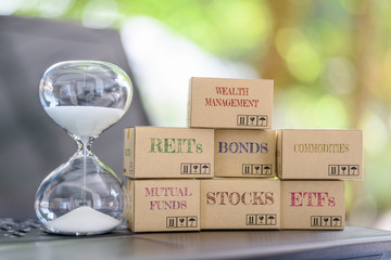 Sandglass, boxes of financial products e.g REITs, bonds, commodities, mutual funds, stocks, ETFs on...