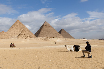 Camel and tourists visiting Giza, Egypt on December 8, 2020.