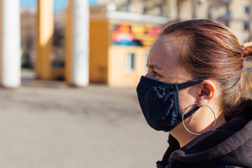 Woman wearing black fabric face mask. Concept of using medical mask to prevent the spread of germs, such as Coronavirus COVID-19.