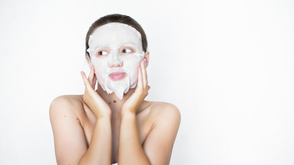 Beautiful woman smoothes, puts on a cosmetic mask on her face. Healthy facial skin. Pore cleansing....