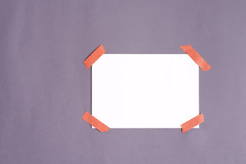 Blank paper frame glued with adhesive tape to light gray backgrround as template for graphic...