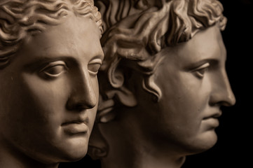 Group gypsum busts of ancient statues human heads for artists on a dark background. Plaster sculptures of antique people faces. Renaissance epoch style. Academic subject. Blank for creativity.
