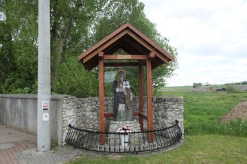 Shrine with a figure of Saint Idzi in the village of Zrebice. Markings of the tourist trail on the pole. Polish countryside, Cracow-Czestochowa Upland, Poland.