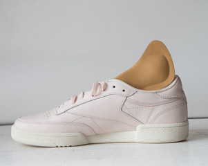Pink running shoe with orthopedic insoles. White background.