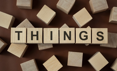 THINGS text made of wooden cube on wooden background.