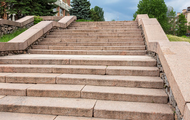 Granite stairs steps background - construction detail. Stone staircase in an urban interior. Granite steps of public city staircase close up