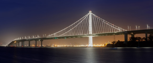 Eastern span of San-Francisco-Oakland Bay Bridge panoramic view at Dusk. Shot from Treasure Island, San Francisco, California, USA.

