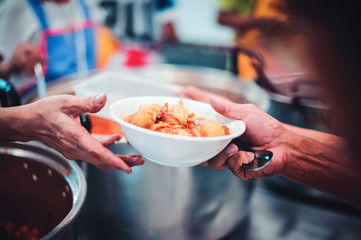 Volunteers give food to the poor : donating food is helping human friends in society