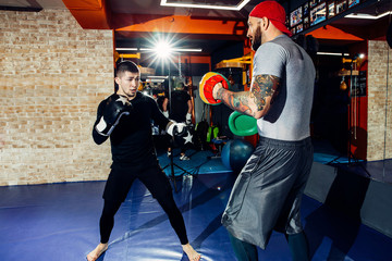 A concentrated professional boxer hits a punching bag.