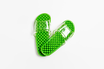 Green rubber slippers on a white background.Rubber slippers. Foot treatment. High-resolution photo.