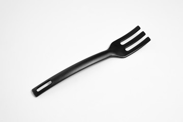 Plastic black fork isolated over the white background. Kitchen utensil.High-resolution photo.