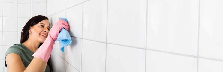 Woman Cleaning The White Tile Of The Wall