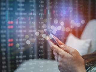 People sue smartphone on desk with with business graph, in concept of business online and finance or stock.
