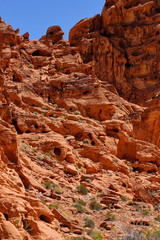 Erosion created small  holes and caves in the Red Aztec Sandstone in the Nevada Desert