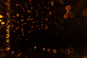 Viele kleine orange Funken auf einem schwarzen Hintergrund.
