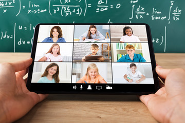 Student Video Conferencing With Happy Female Teacher On Tablet