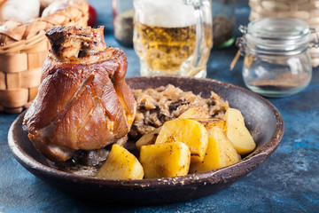 Pork knuckle with fried sauerkraut and baked potatoes