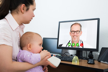 Woman With Her Baby Using Computer