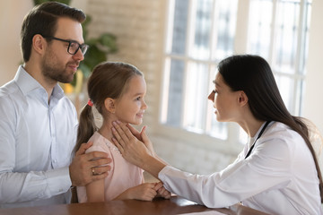 Female pediatrician examine do checkup of little girl child patient at visit or consultation with dad, caring father with small daughter consult with woman doctor or GP in clinic, healthcare concept
