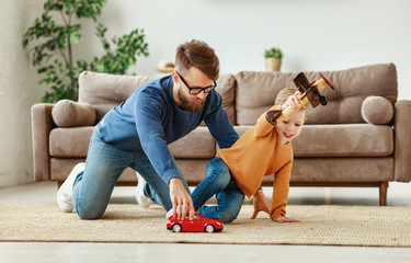 Young father and kid playing with toys at home.