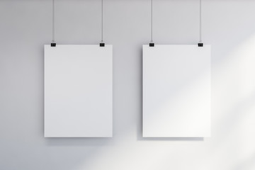 Two vertical mock up posters on white wall