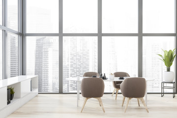 White dining room with brown armchairs