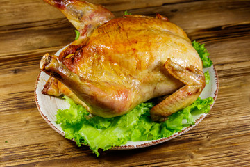 Baked whole chicken on a wooden table