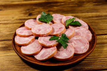 Ham sausage on a plate on wooden table