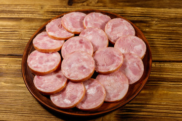 Ham sausage on a plate on wooden table
