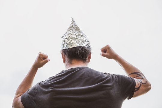 Man with a tin foil hat on his head demonstrate angry, concept conspiracy theory and schwurbler
