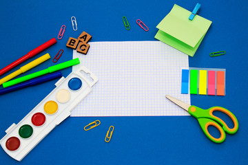 School tools, equipment (scissor, pen, paper, pencil, clips, headphones) on dark blue bacground. Copy space