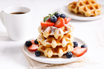 belgian waffles with fresh blueberries, strawberries and sugar.