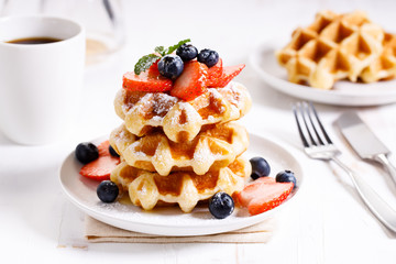 belgian waffles with fresh blueberries, strawberries and sugar.