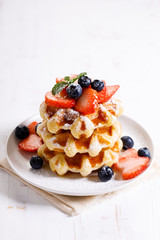 belgian waffles with fresh blueberries, strawberries and sugar.