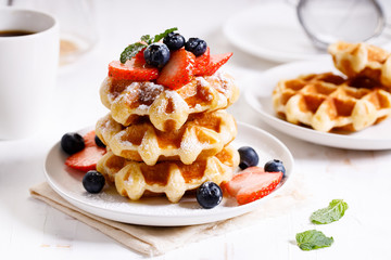 belgian waffles with fresh blueberries, strawberries and sugar.